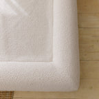 Close-up of the soft, textured 690GSM cream boucle fabric cover on the dog bed