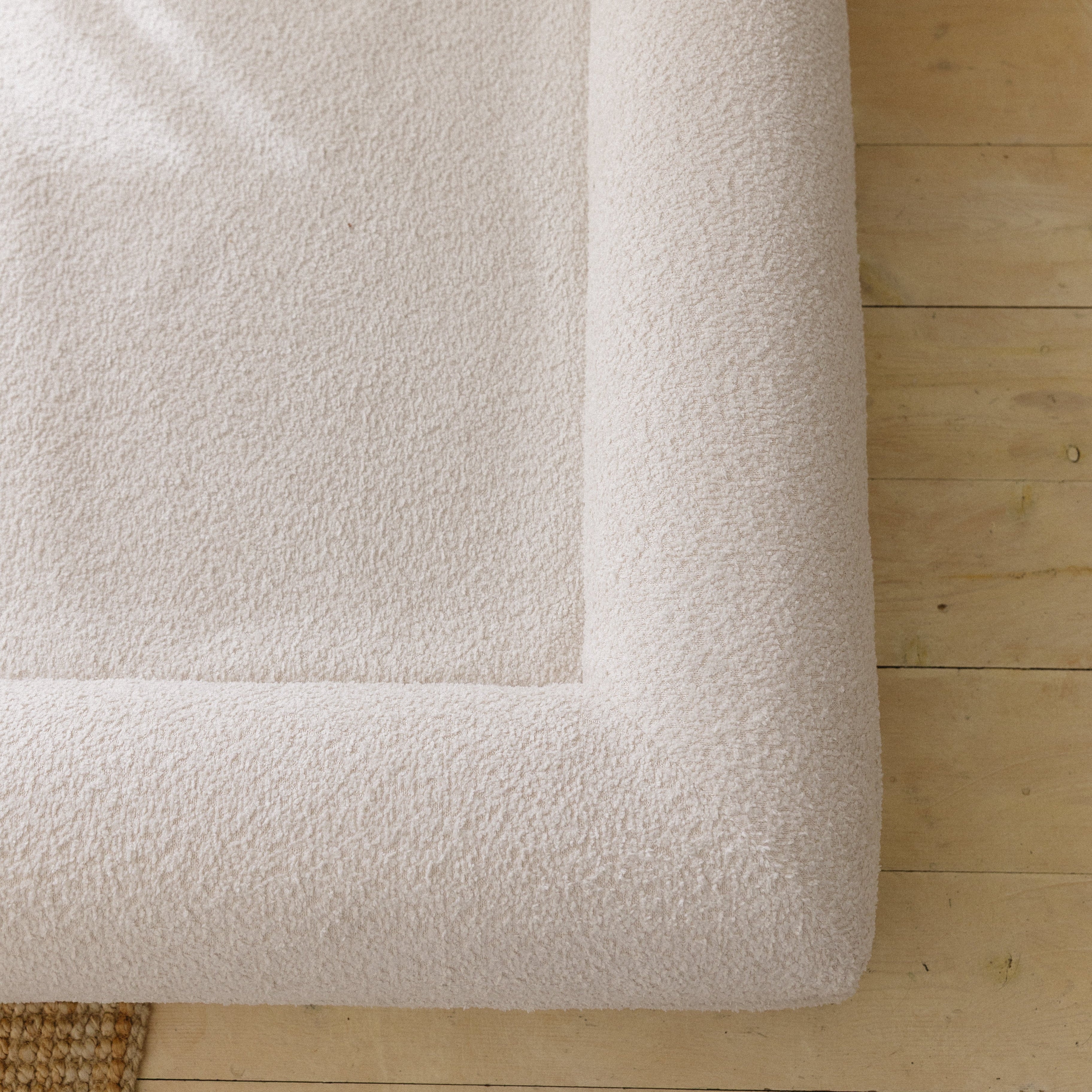Close-up of the soft, textured 690GSM cream boucle fabric cover on the dog bed