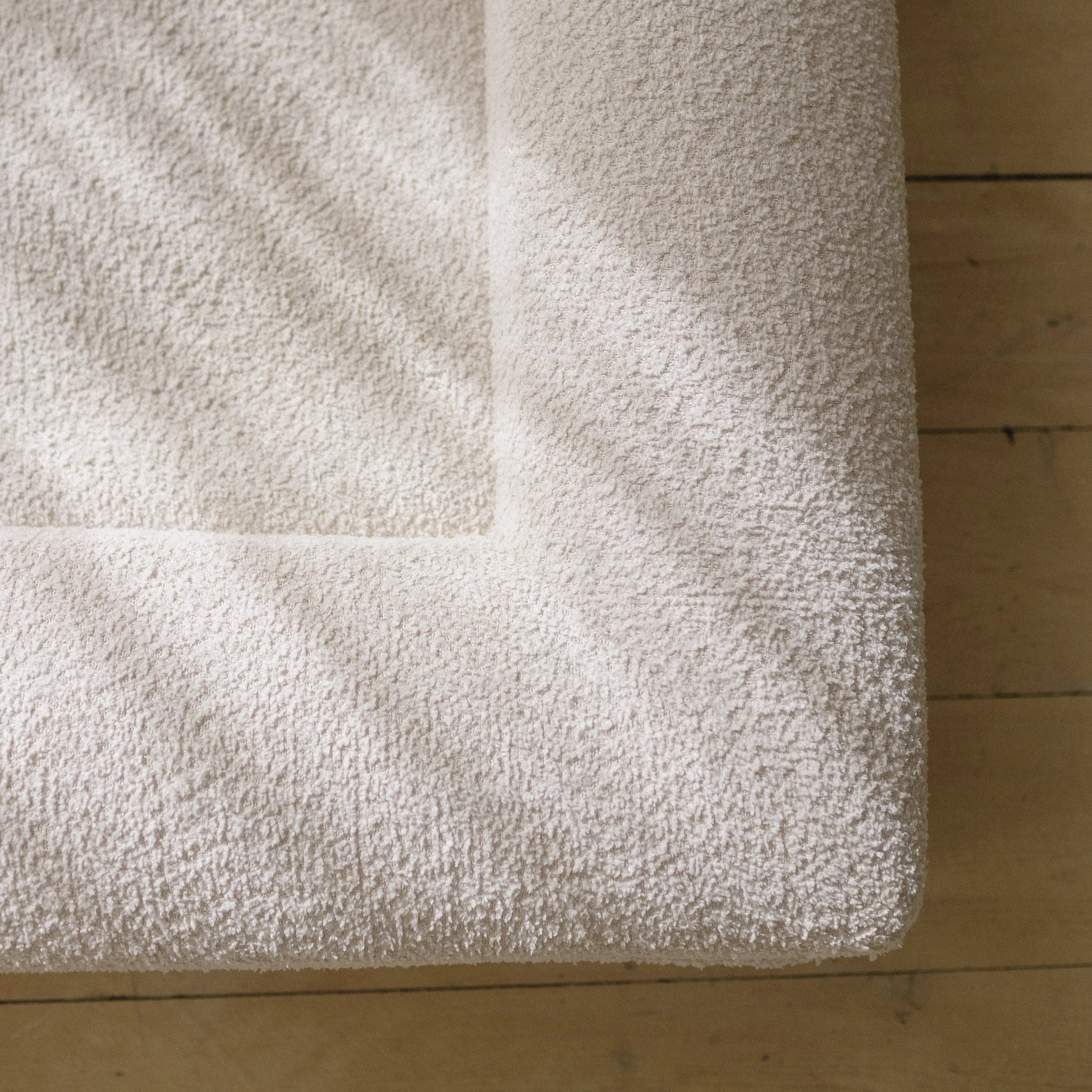 Close-up of the soft, textured 690GSM cream boucle fabric cover on the dog bed