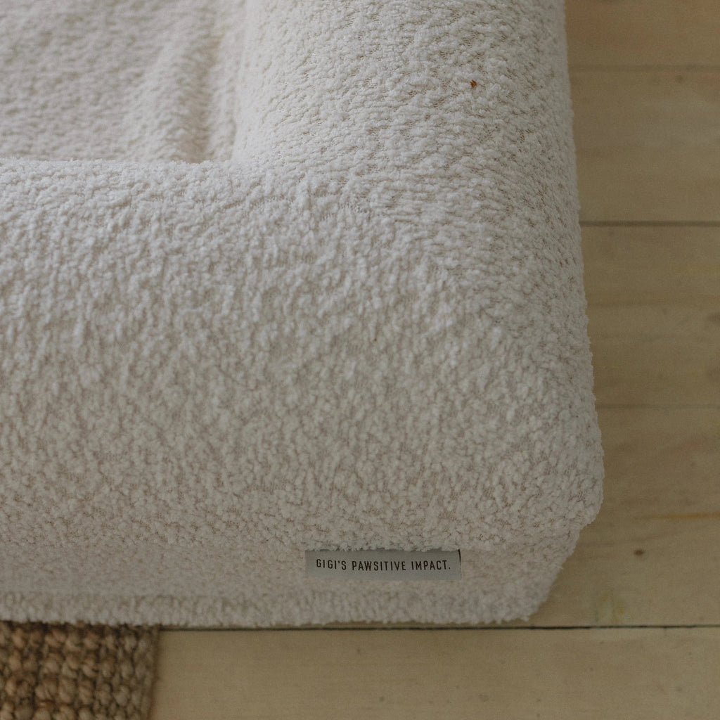Close-up of the soft, textured 690GSM cream boucle fabric cover on the dog bed