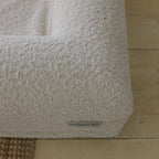 Close-up of the soft, textured 690GSM cream boucle fabric cover on the dog bed