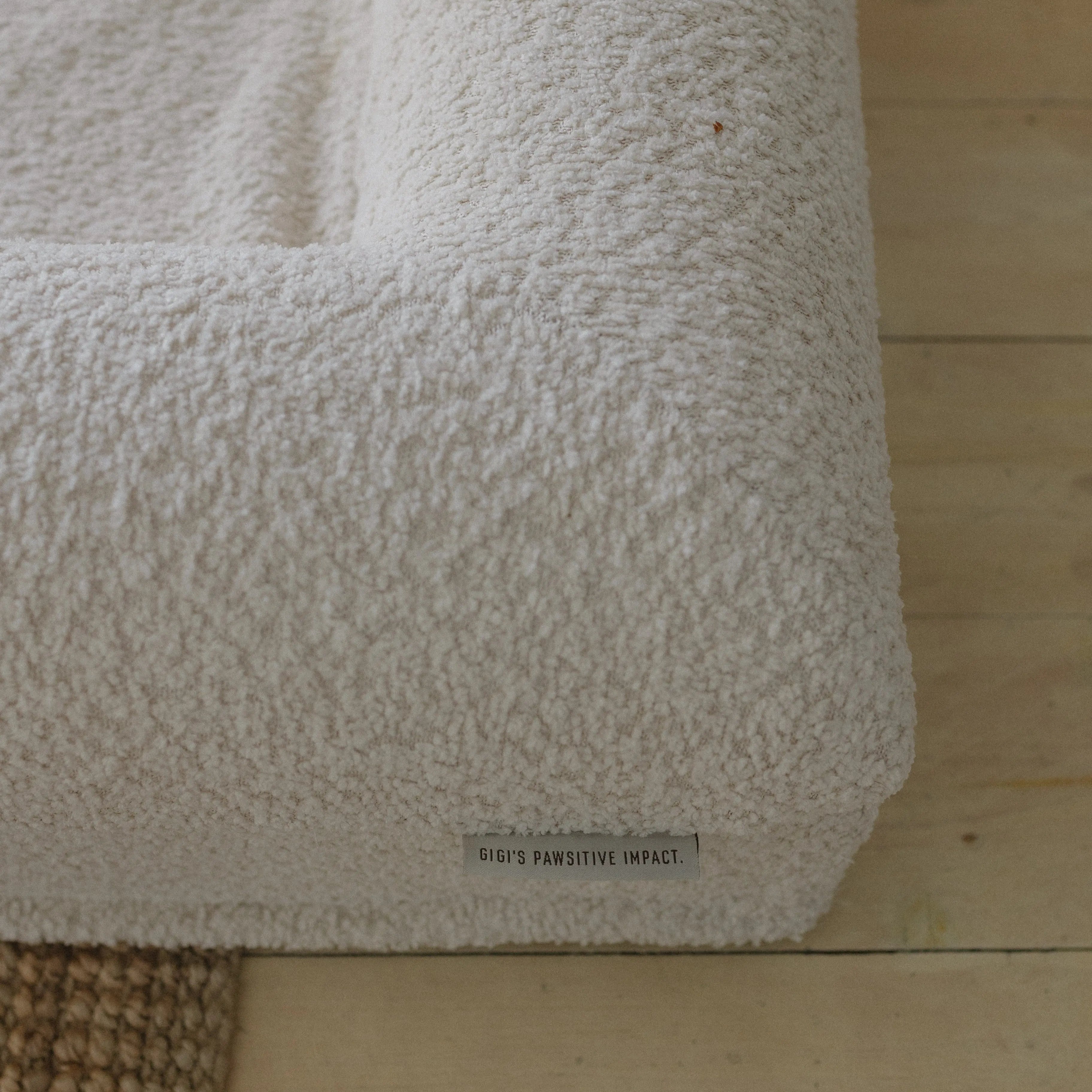 Close-up of the soft, textured 690GSM cream boucle fabric cover on the dog bed